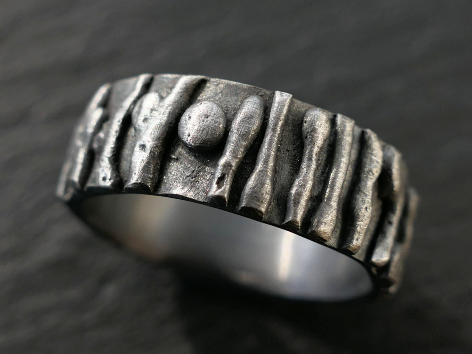 Dark silver rustic men's bark ring made of sterling silver with textured tree bark design and unique twigs pattern.