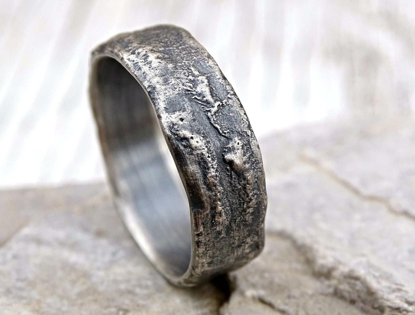 dark men's silver wedding band with textured molten sterling silver surface and oxidized finish