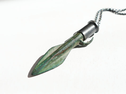 Ancient green bronze Scythian arrowhead pendant with dark oxidized sterling silver setting and black chain.