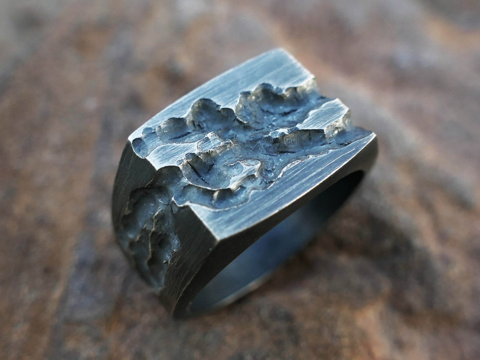 Distressed blackened sterling silver signet ring with rugged textured rectangular plate and tapered band