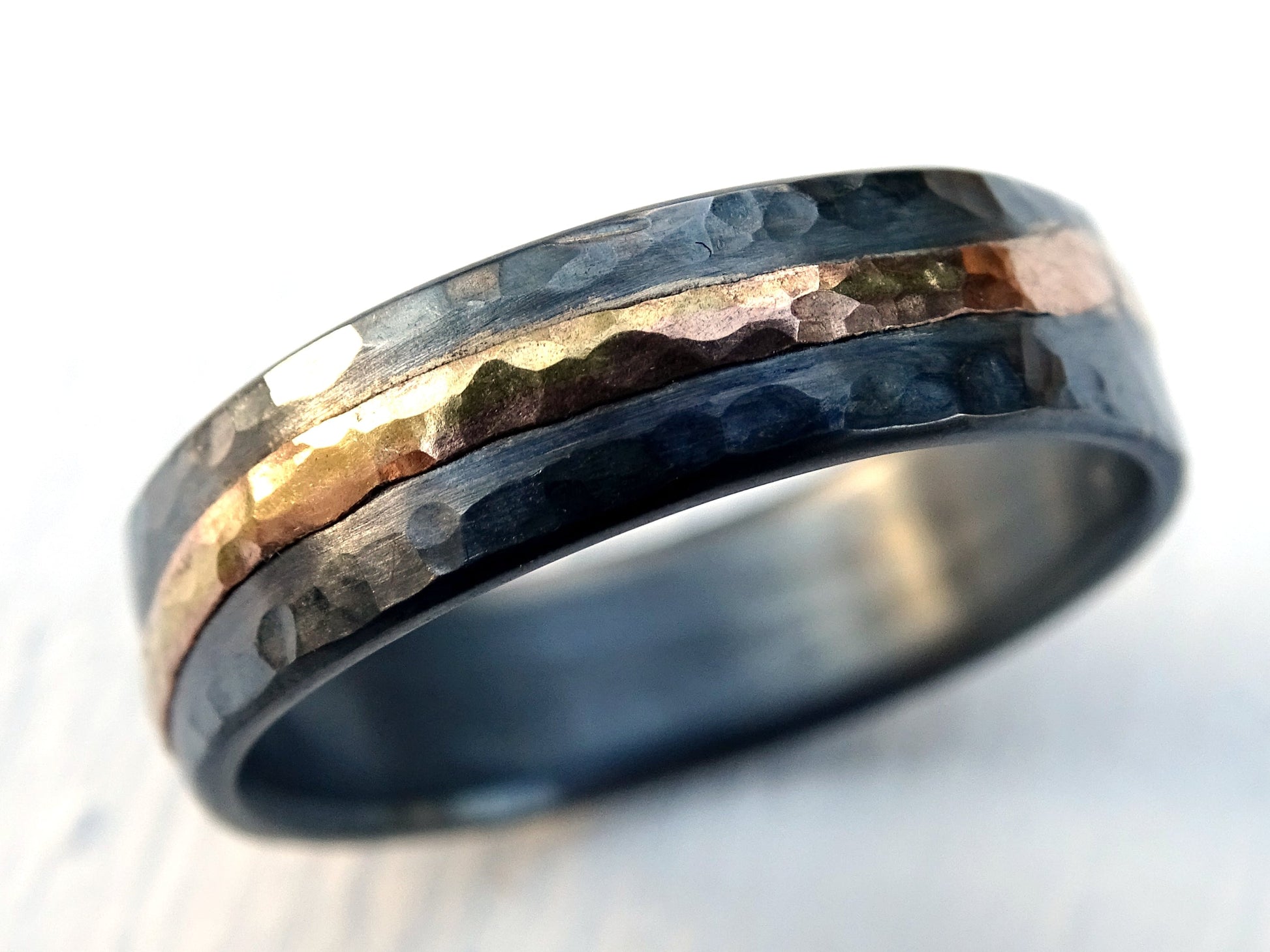handmade wedding ring with hammered sterling silver and 14k gold accent band with dark oxidized finish