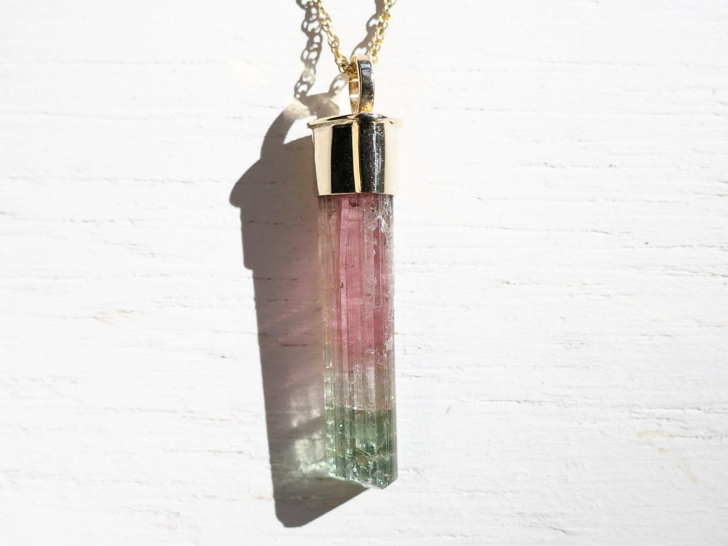 Watermelon tourmaline 14k gold necklace with pink and green crystal pendant.