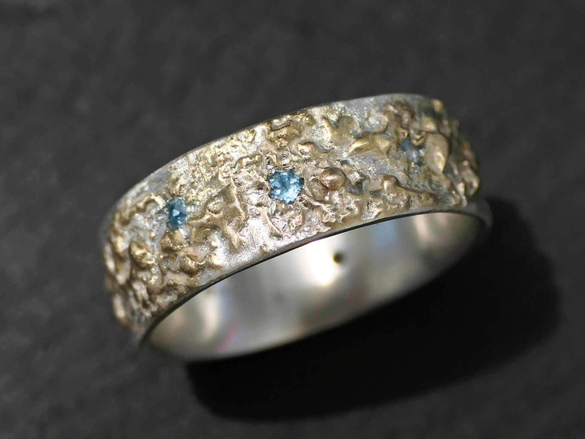 handmade two-tone silver and 14k gold aquamarine ring with textured surface and scattered gemstones