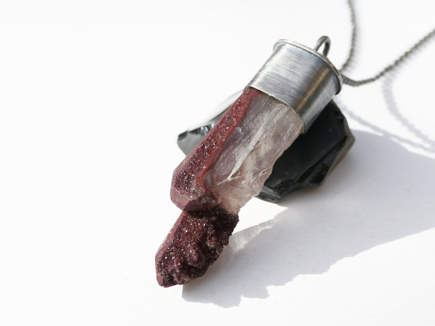 Big hematite quartz crystal pendant in dark sterling silver setting on a chain.