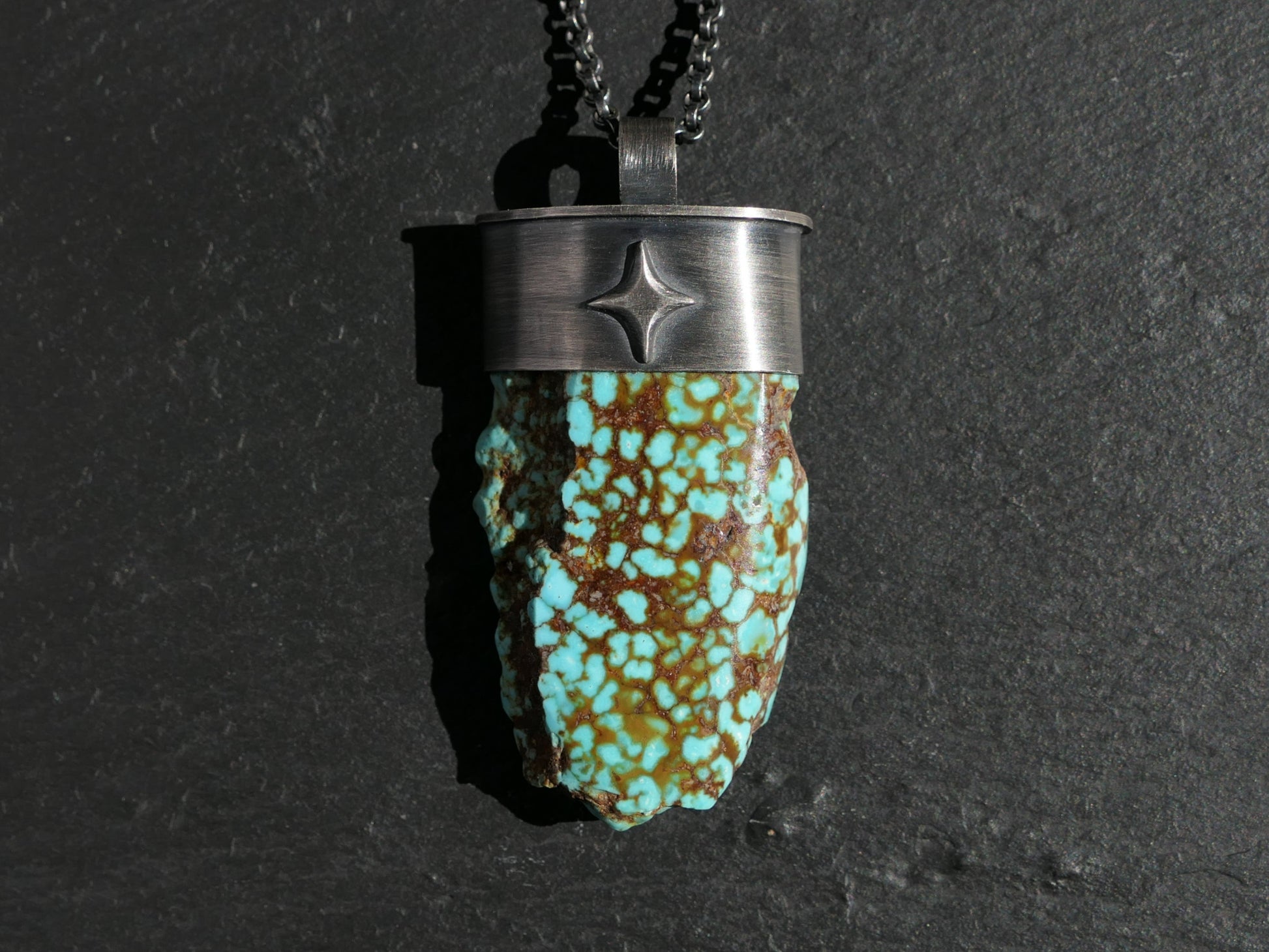 Kingman turquoise nugget pendant in dark oxidized sterling silver with unique brown webbing on black chain