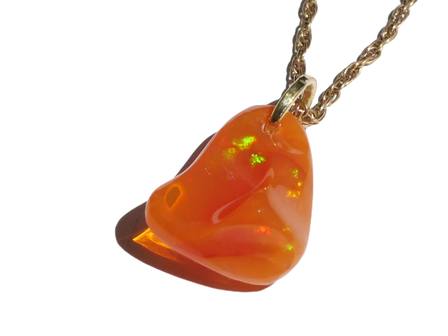 Carved Mexican fire opal pendant with 18k yellow gold bail and chain, showcasing vibrant orange hues and color play.