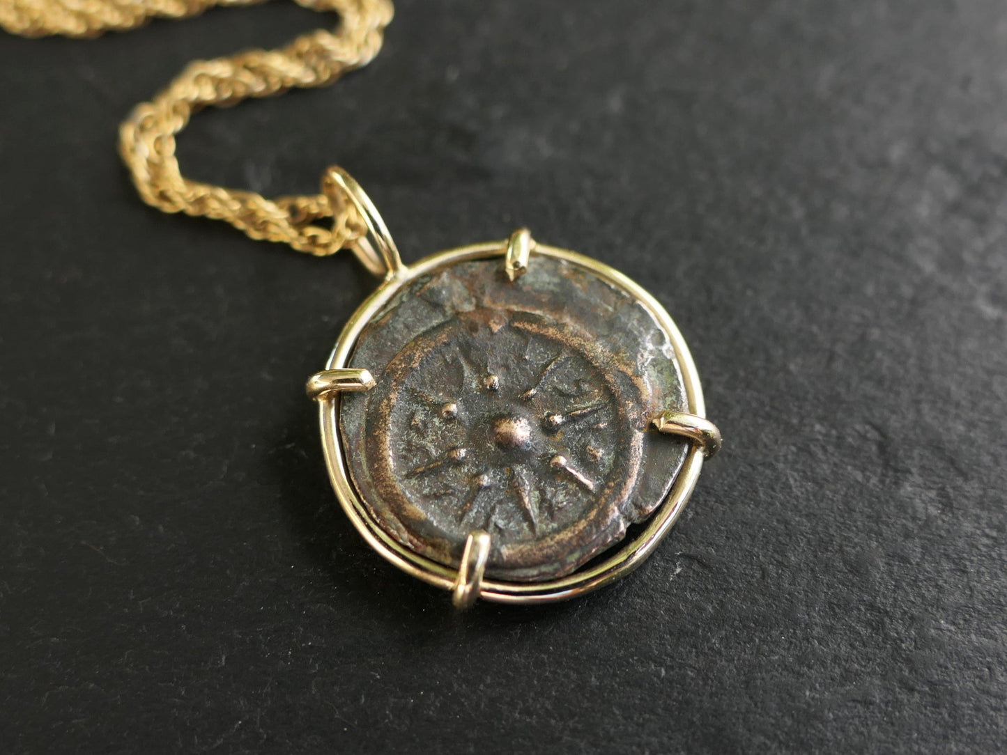 Ancient widows mite bronze coin pendant set in 14k gold with chain, detailed craftsmanship.