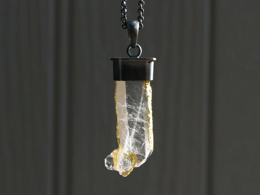 Clear quartz crystal necklace with natural gold leaf accents set in black oxidized sterling silver