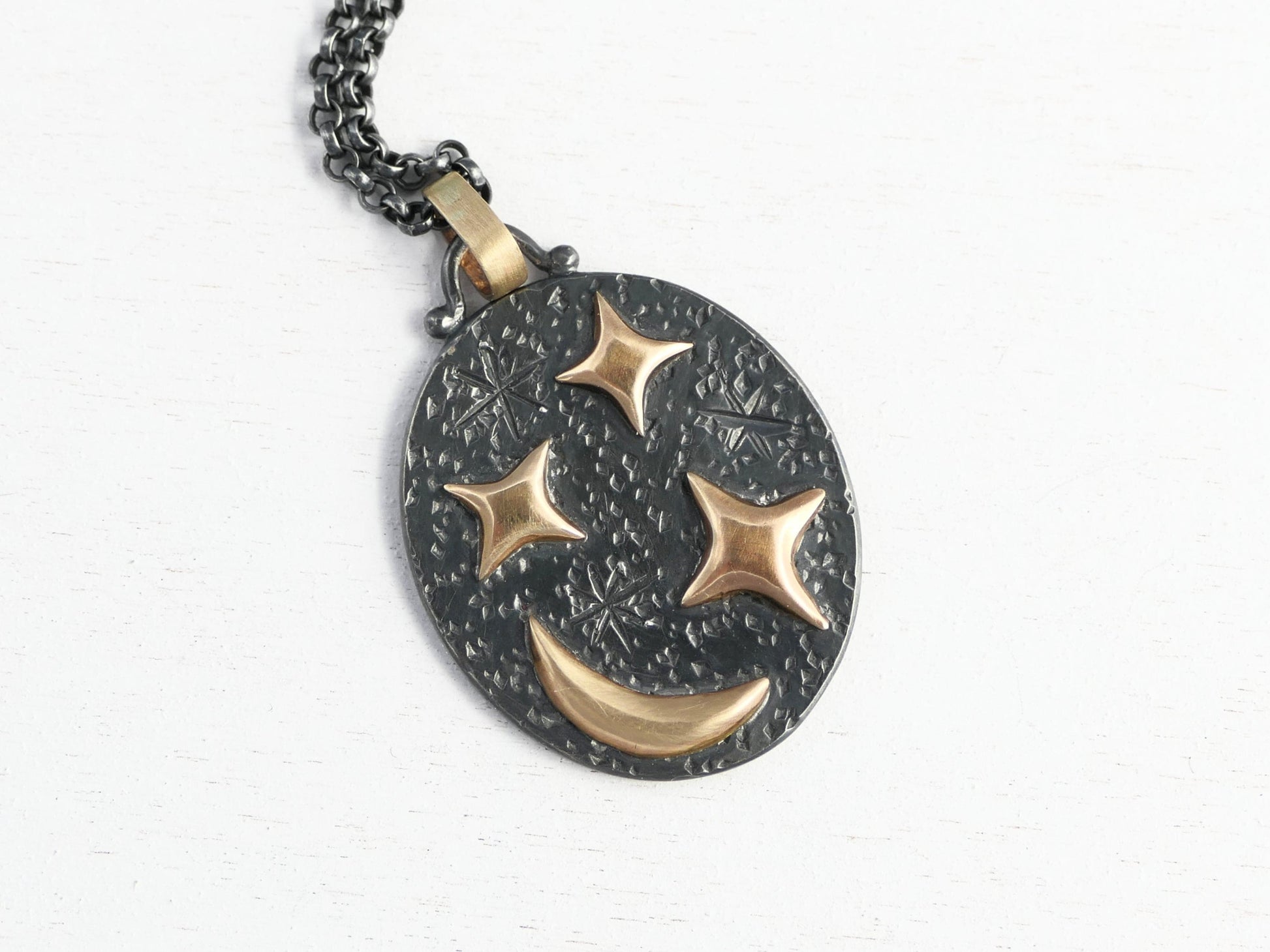 Black silver oval pendant with 14k gold crescent moon and stars on black sterling silver chain