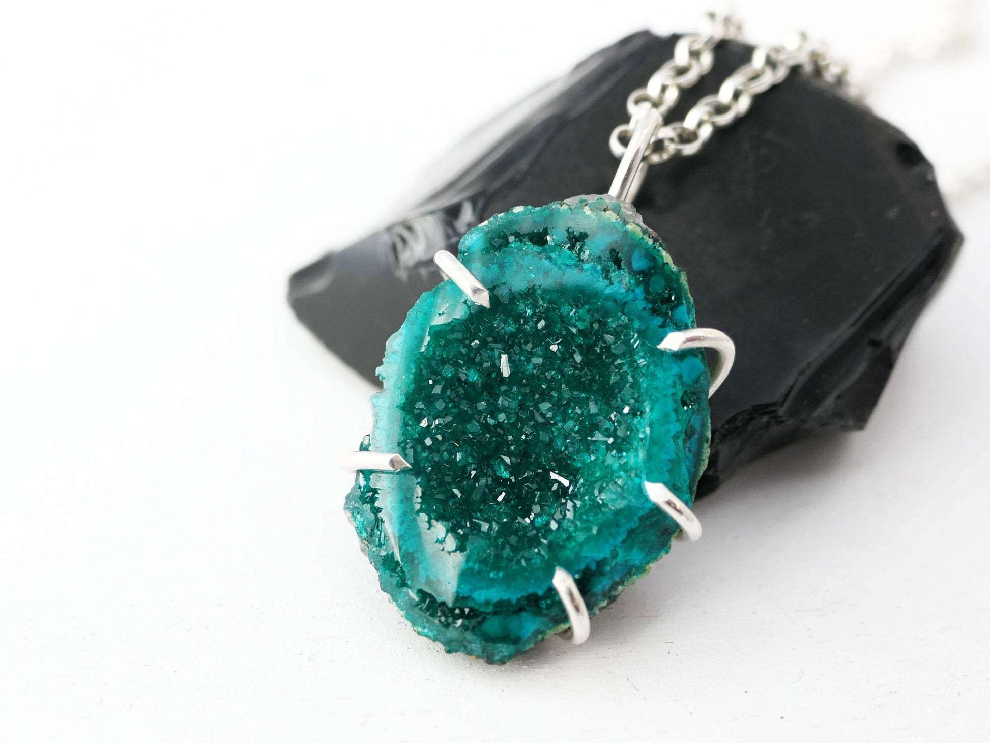 Minimalist dioptase crystal necklace in sterling silver setting with rolo chain.