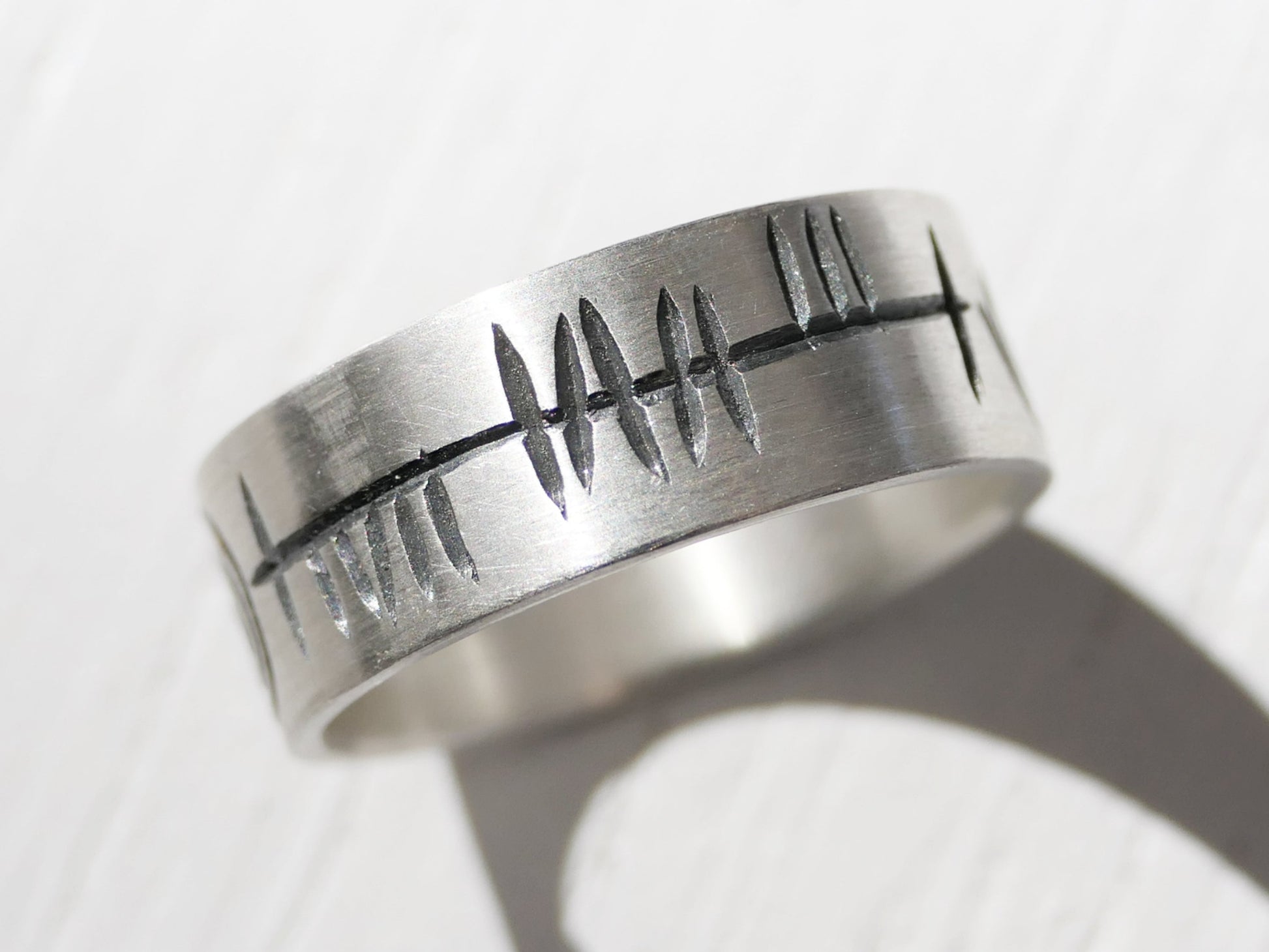 Handmade sterling silver Ogham ring with rustic engraved Ogham script on a 7mm wide band