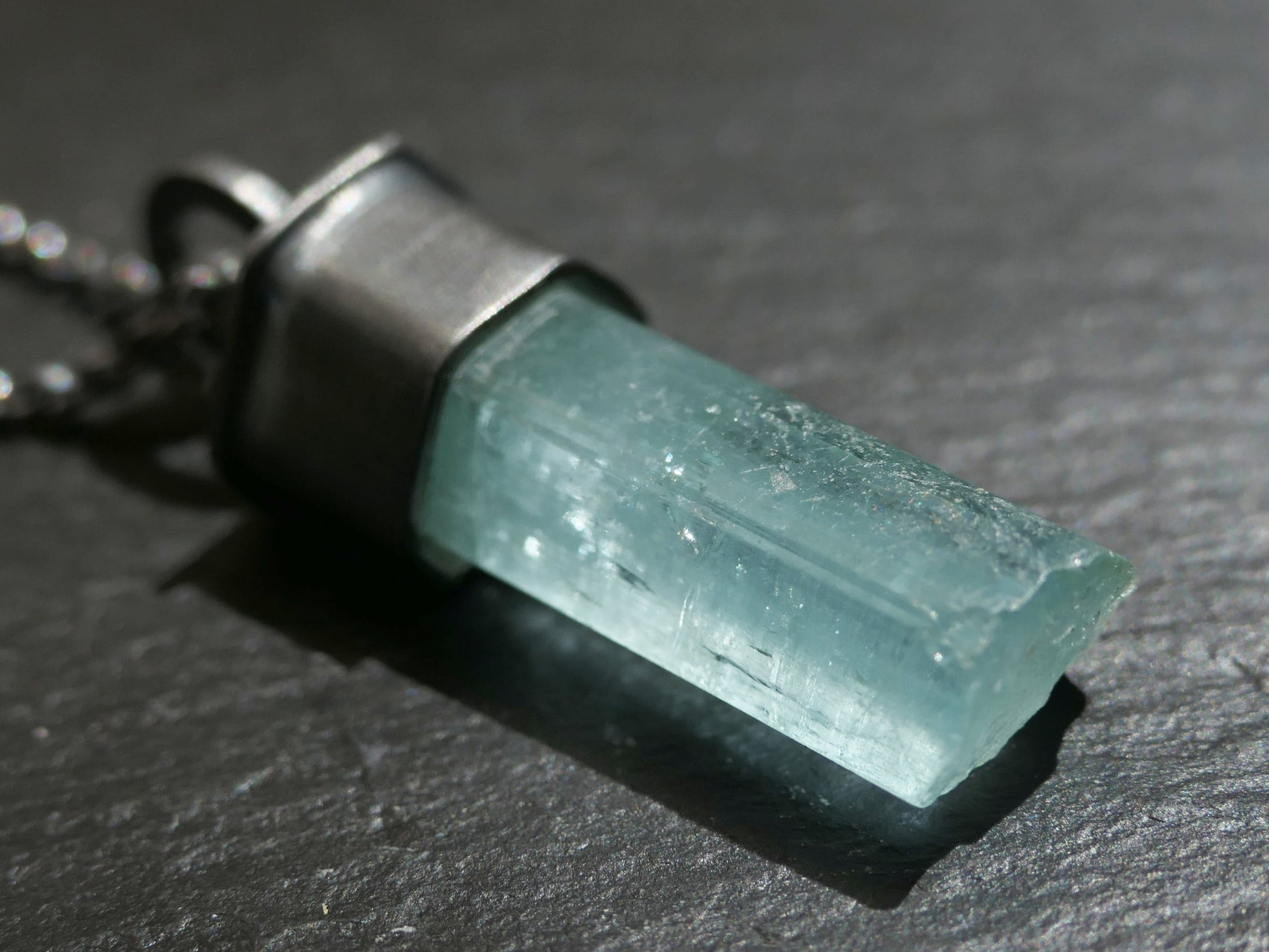 Greenish blue raw aquamarine crystal necklace with black silver setting and chain