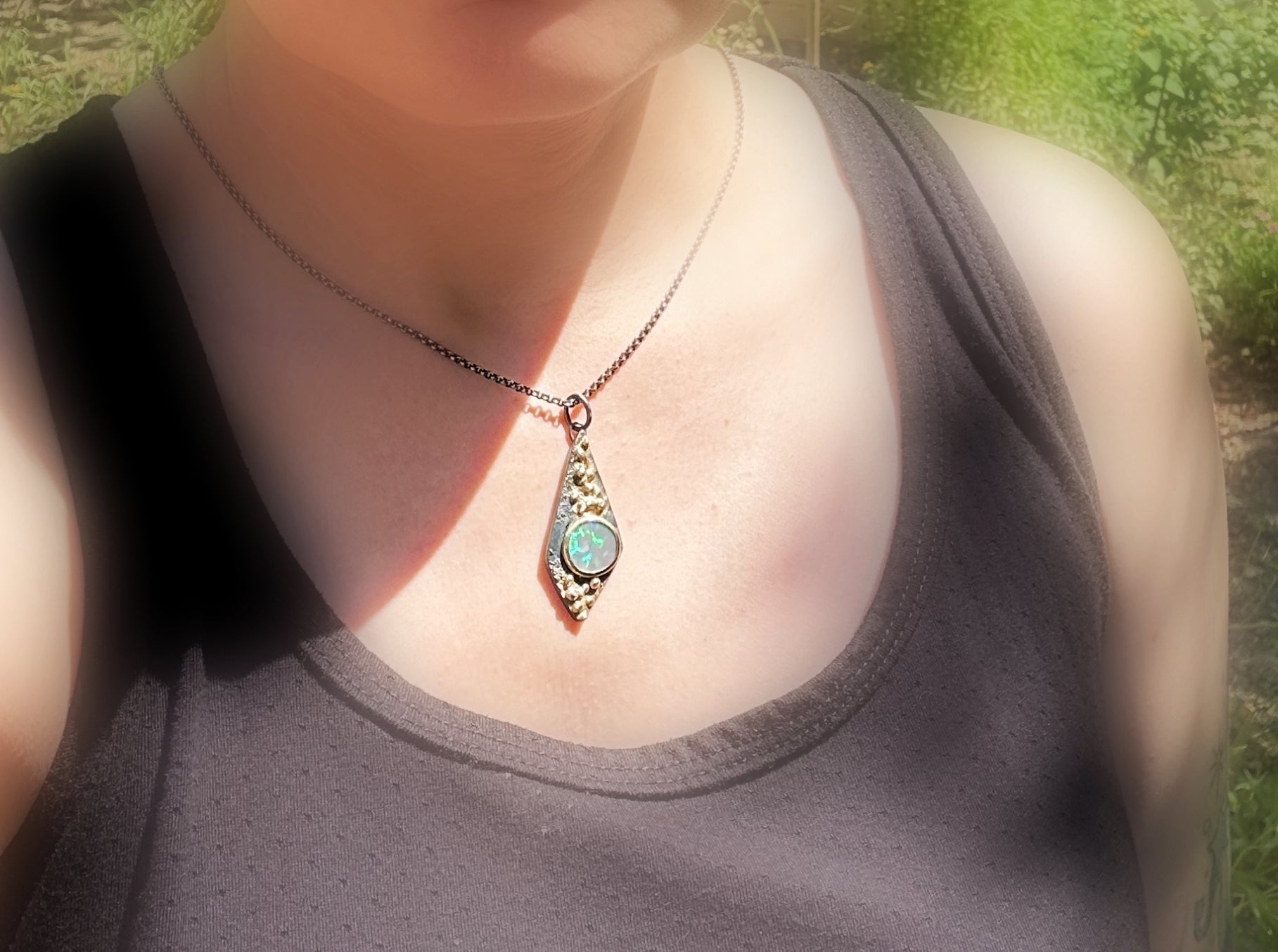 handmade black opal pendant on a neck