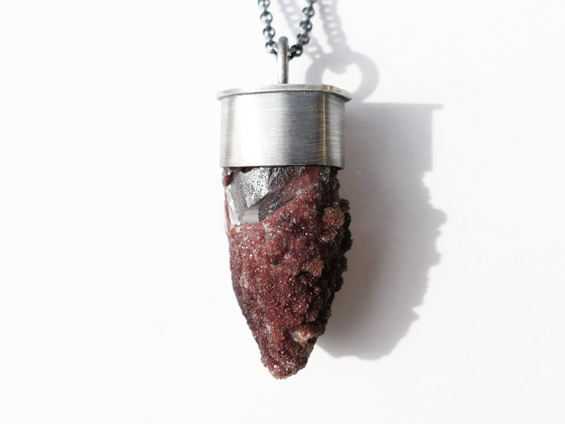 Red hematite quartz crystal necklace in dark oxidized sterling silver setting.
