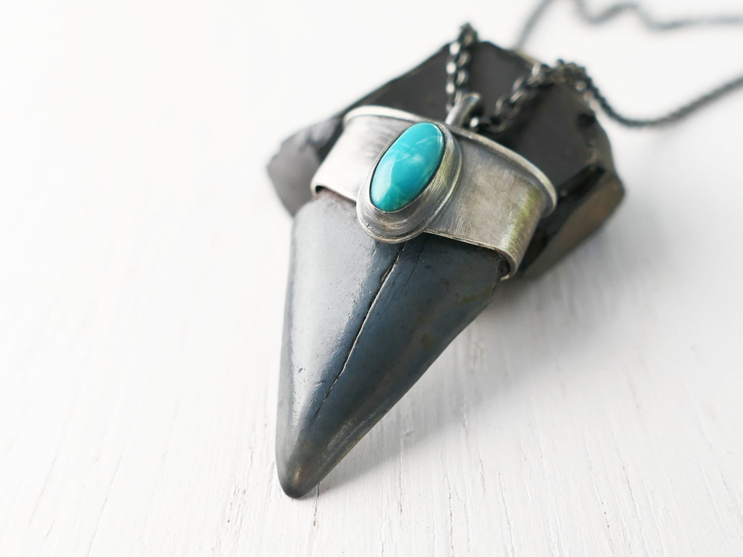 Hastalis shark tooth pendant in sterling silver with turquoise gemstone on black silver chain