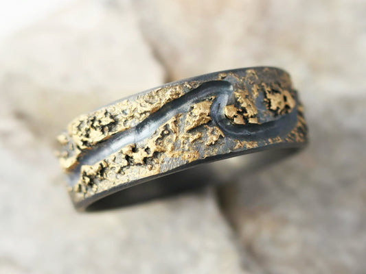 Handmade silver and 14k gold wave ring with engraved wave pattern and textured molten gold surface