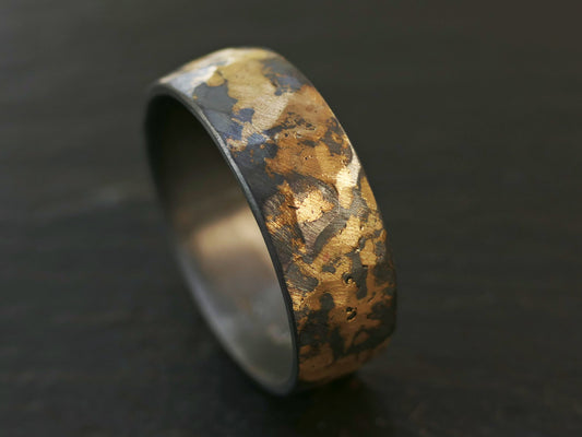 forged men's wedding band in gold and dark silver with hammered texture