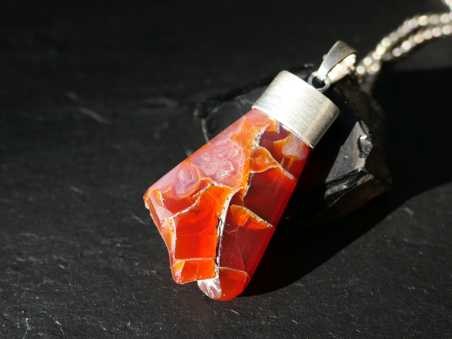 Chunky red Mexican fire opal pendant set in sterling silver with unique polished and raw surface details.