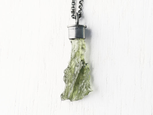 Uncut green moldavite crystal pendant in black sterling silver setting on chain