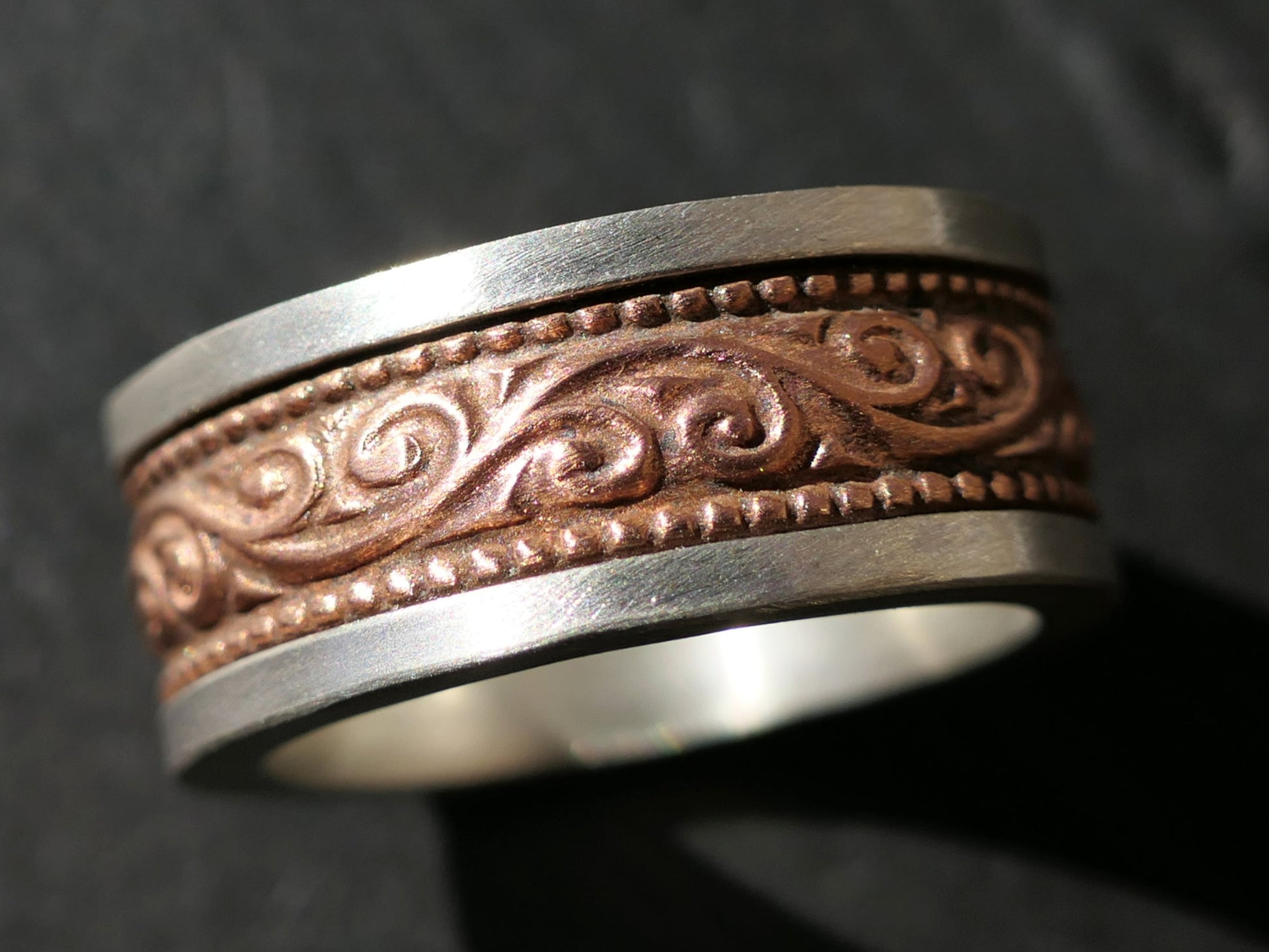 Sterling silver men's wedding ring with patterned copper inlay and matte finish band