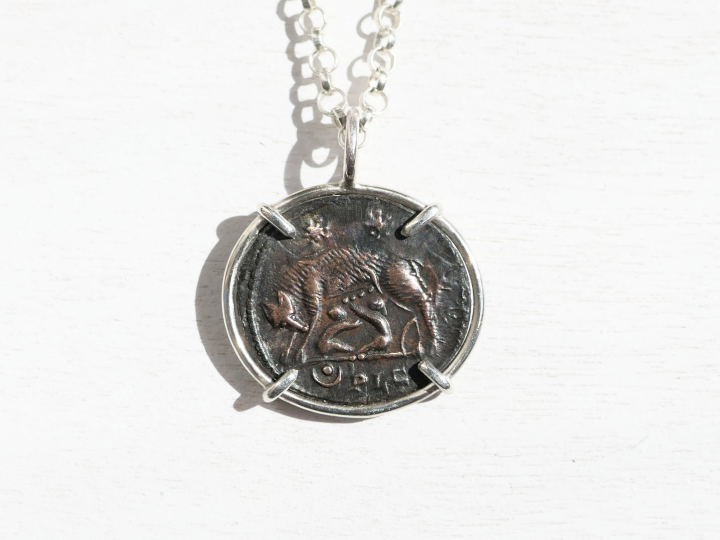 ancient Urbs Roma coin necklace with sterling silver setting and chain featuring authentic Roman Empire she-wolf coin.