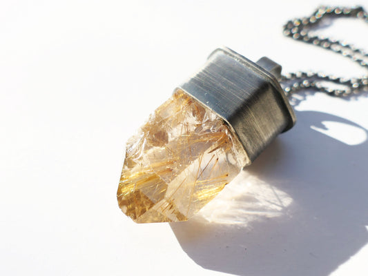 Large Rutile quartz necklace with golden needles in oxidized sterling silver setting.