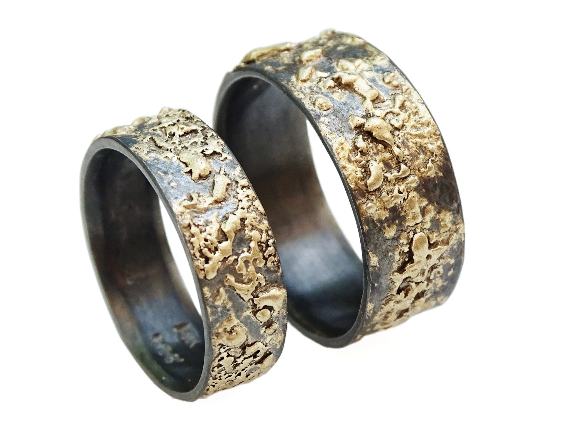 Handmade his and hers wedding rings set in dark oxidized sterling silver with unique fused 14k gold patterns and wide bands.