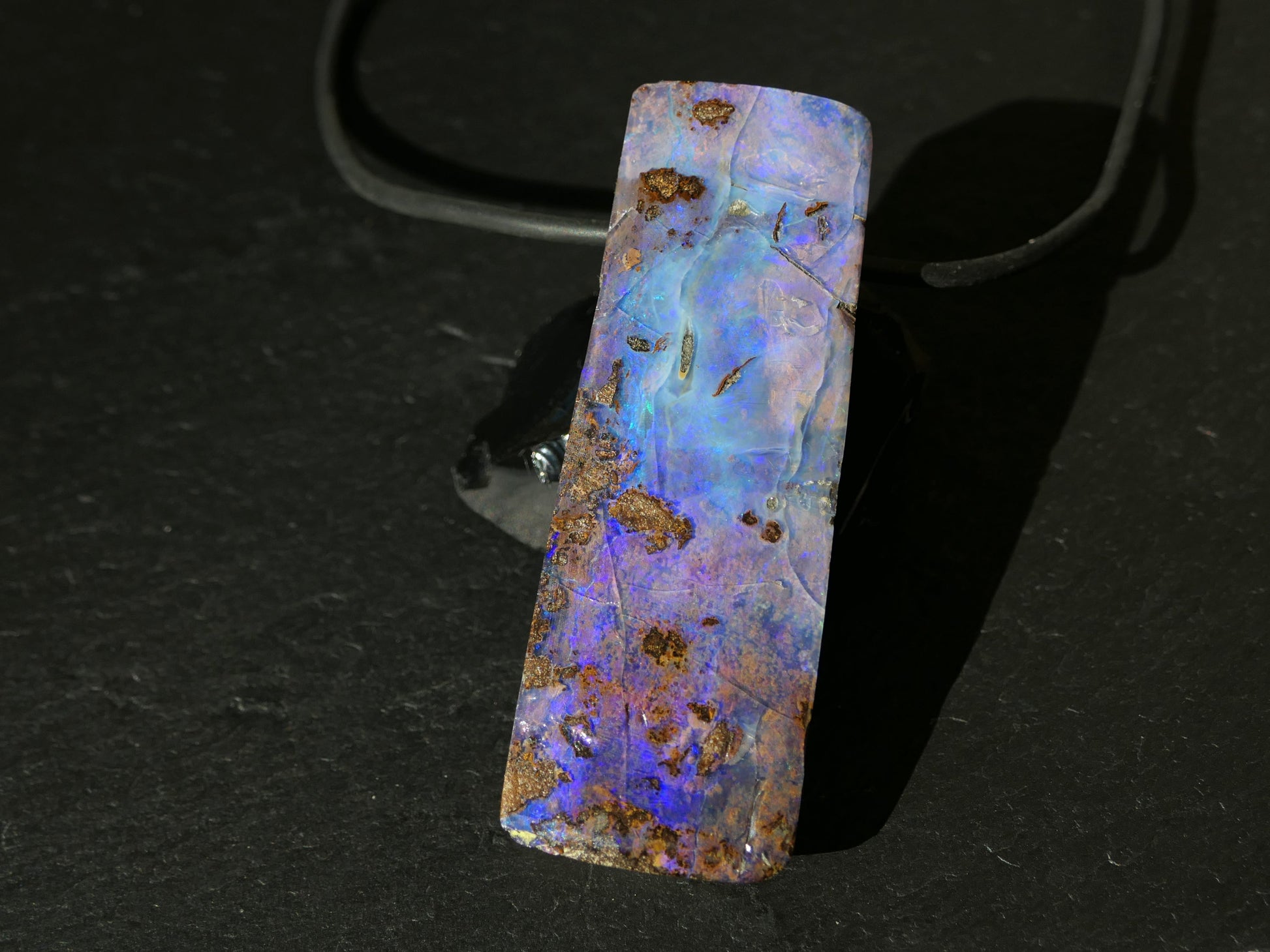 Statement sized purple and blue Australian boulder opal pendant on black neoprene cord with sterling silver clasp