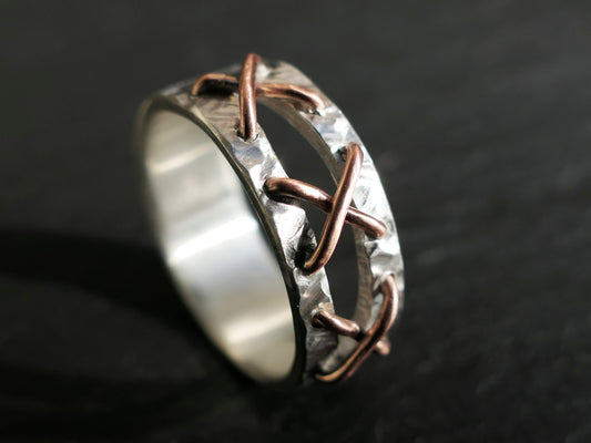 Handmade sterling silver stitched ring with copper cross stitches and split band design