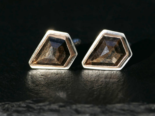 Golden sheen sapphire cufflinks with faceted shield cut set in sterling silver and bronze, displayed on dark surface