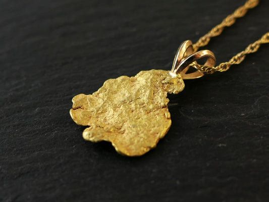Real Alaska gold nugget pendant with natural gold texture on gold-filled chain against black background