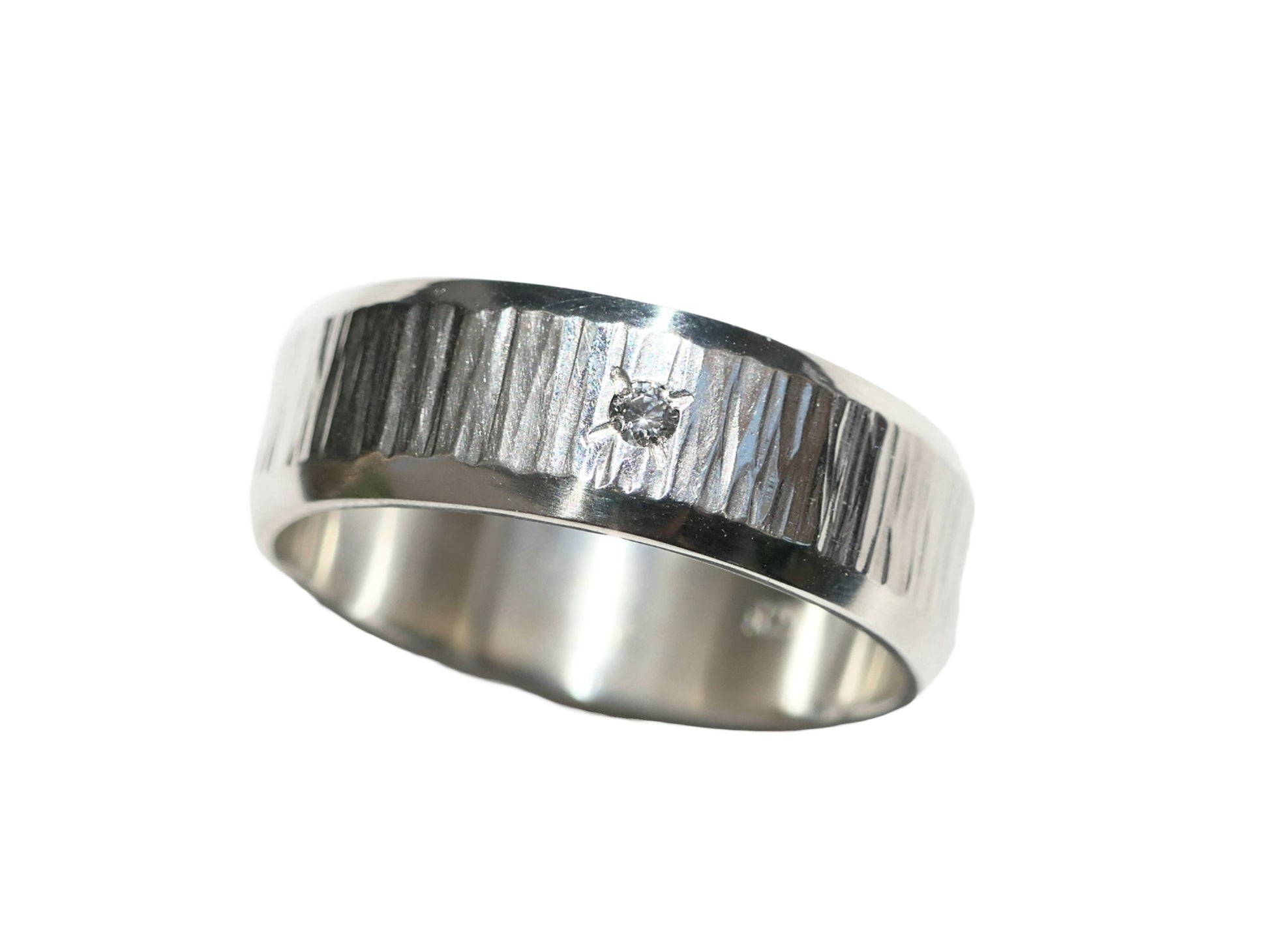 silver wedding band with white gemstone on white background