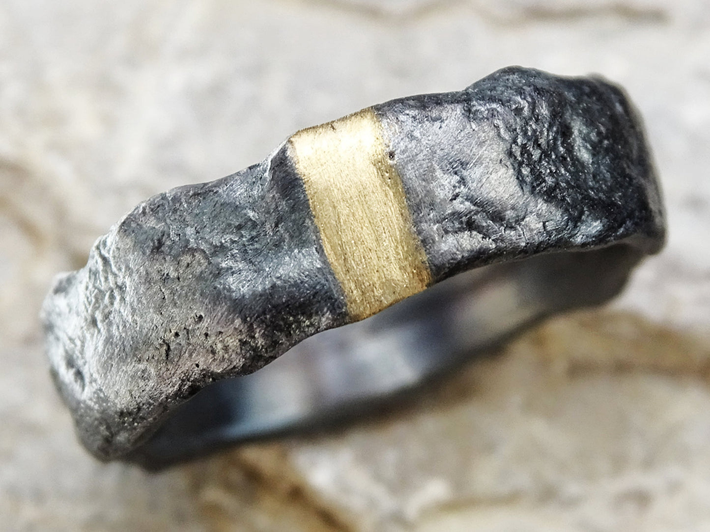 modern mens wedding band with molten oxidized silver texture and 14k gold inlay center strip
