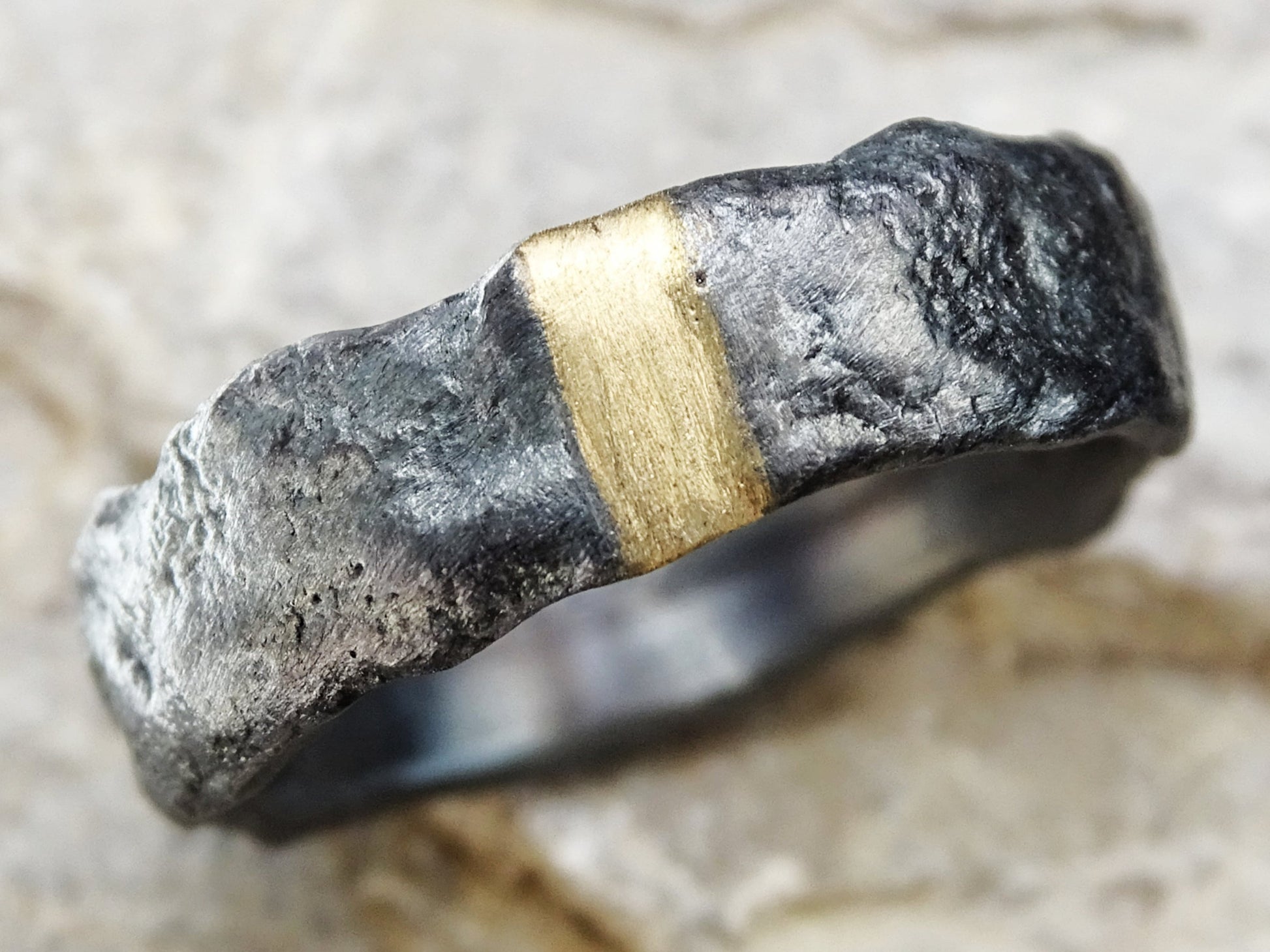 modern mens wedding band with molten oxidized silver texture and 14k gold inlay center strip