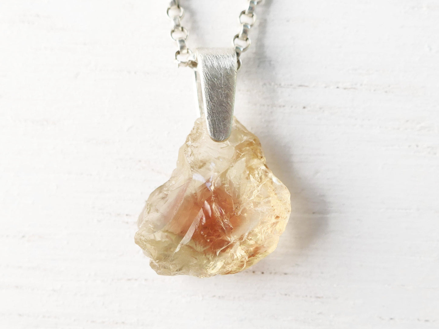 Raw Oregon sunstone pendant with sterling silver bail and chain showcasing natural uncut gemstone