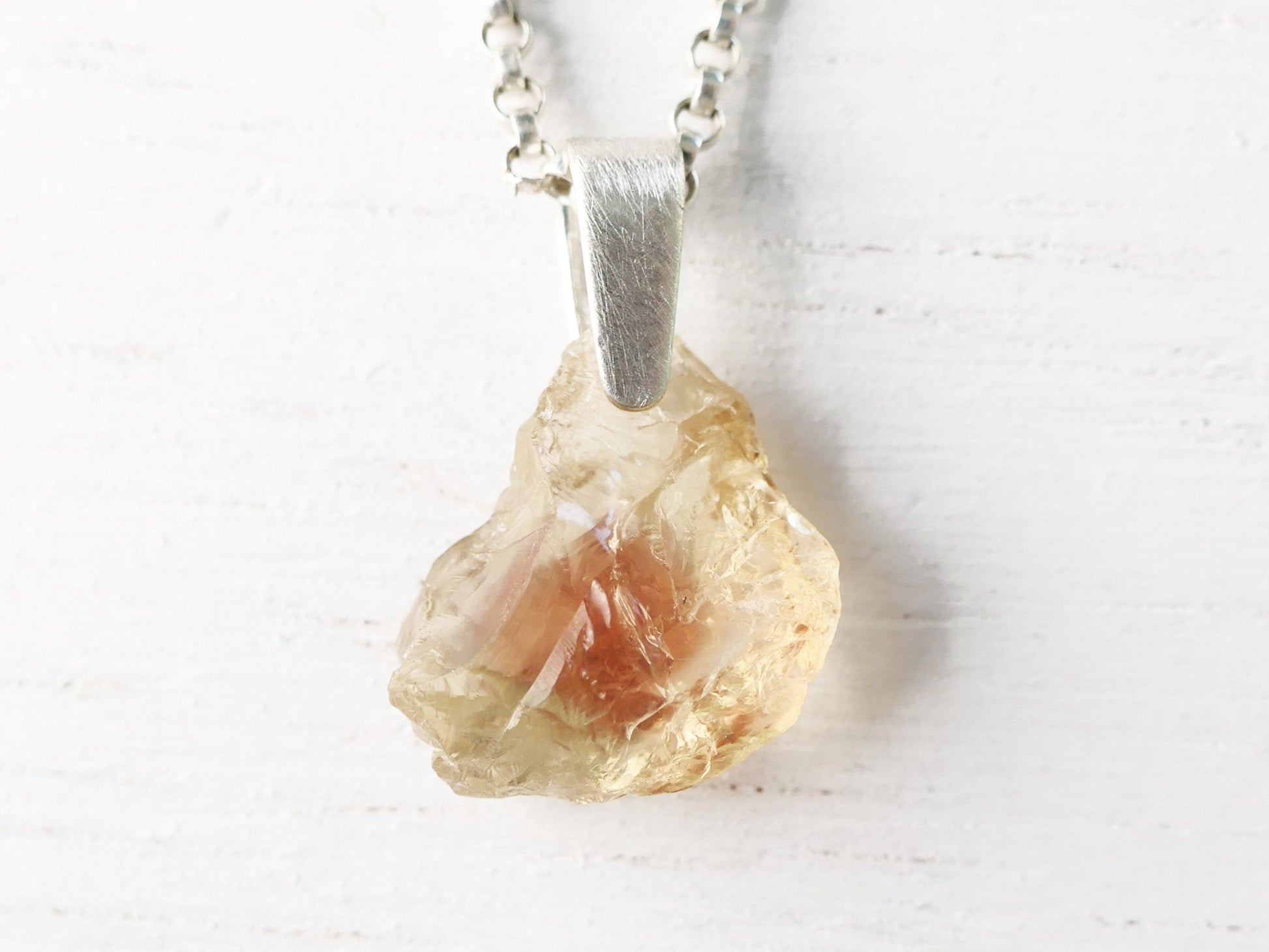 Raw Oregon sunstone pendant with sterling silver bail and chain showcasing natural uncut gemstone