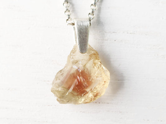 Raw Oregon sunstone pendant with sterling silver bail and chain showcasing natural uncut gemstone