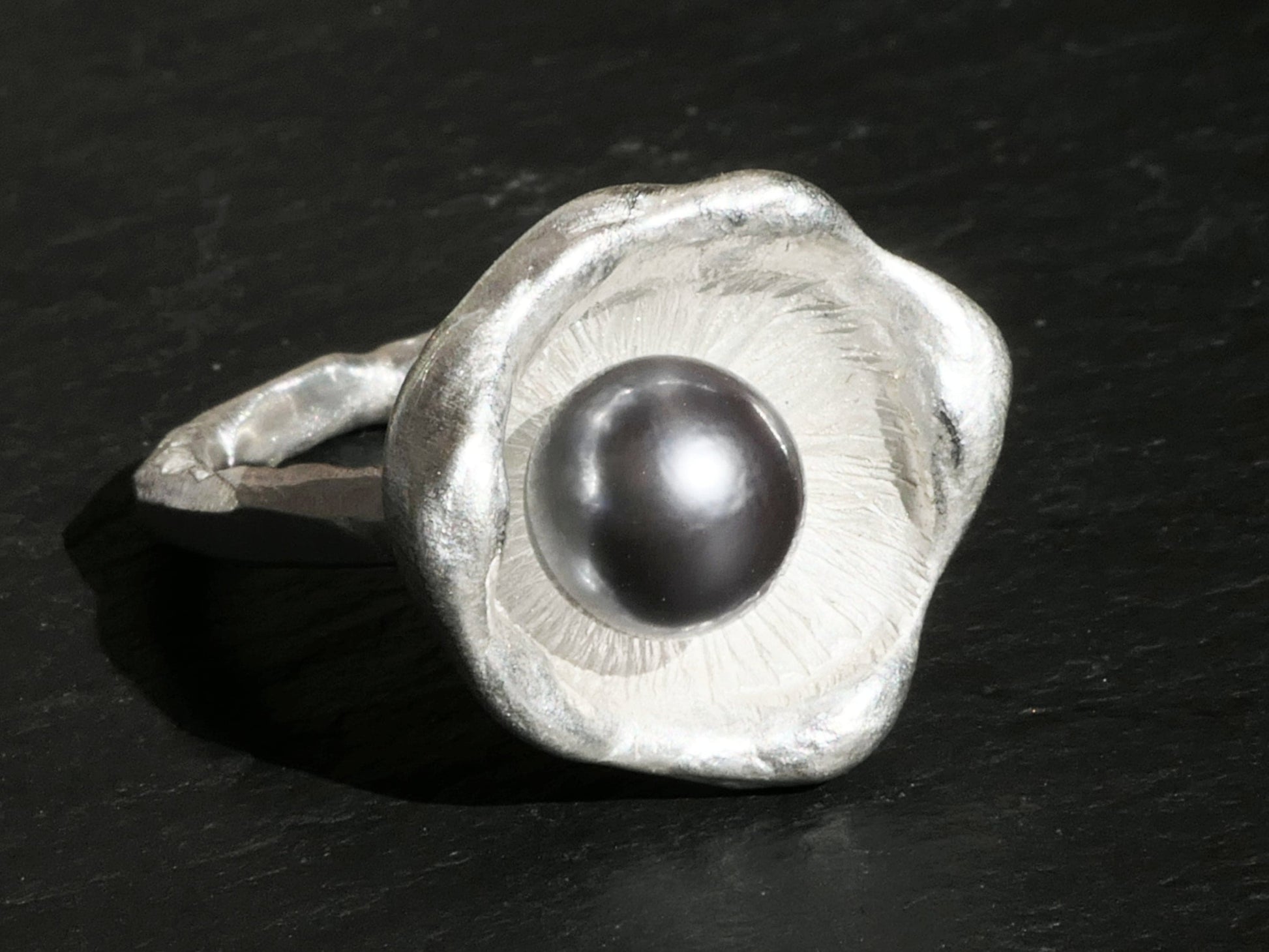 Sterling silver ring with a round grey Tahiti pearl set in a unique watercast dish design