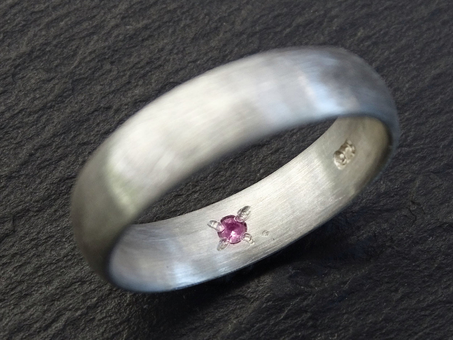 Sterling silver domed ring with a hidden pink gemstone set inside the band