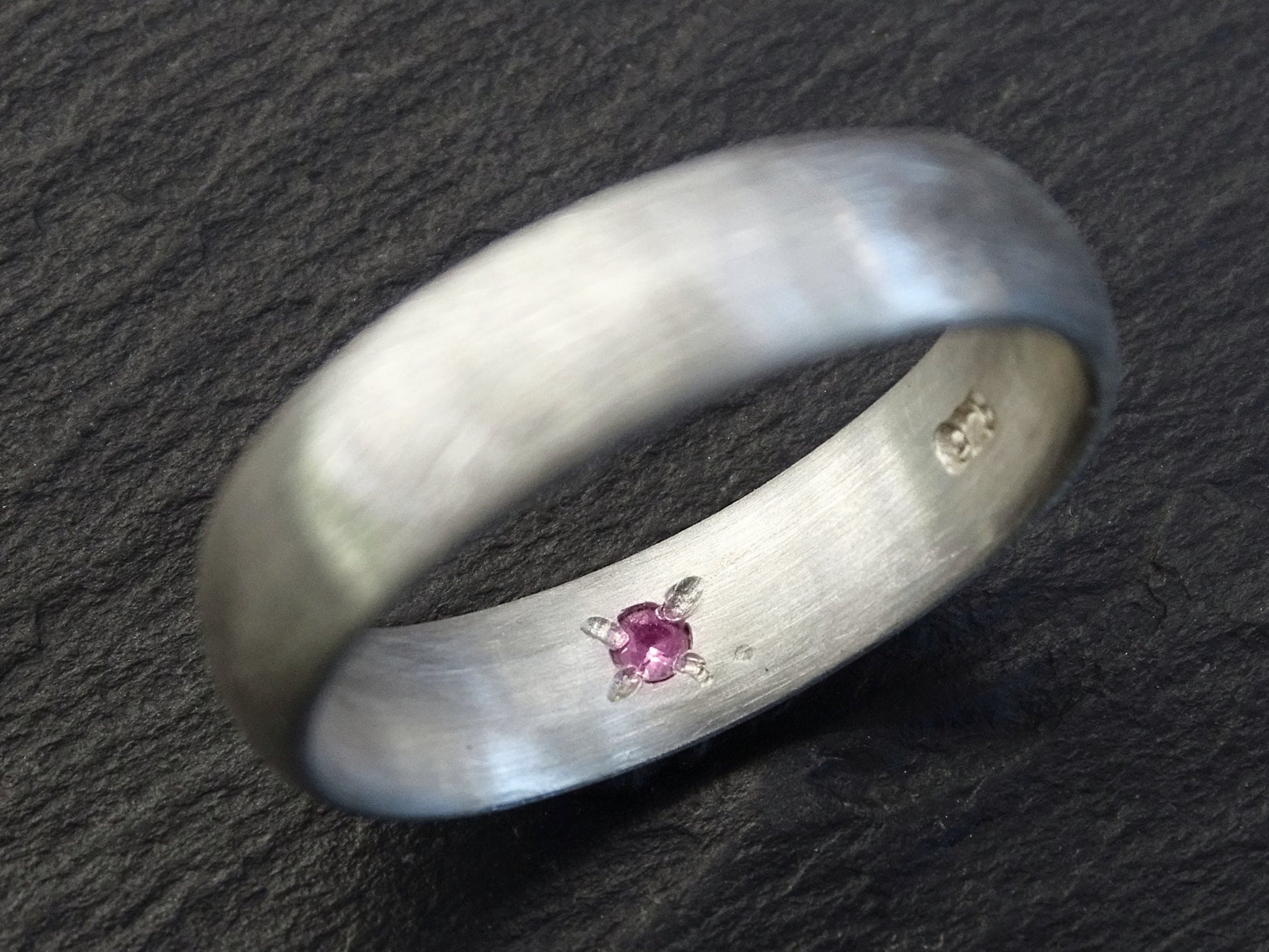 Sterling silver domed ring with a hidden pink gemstone set inside the band