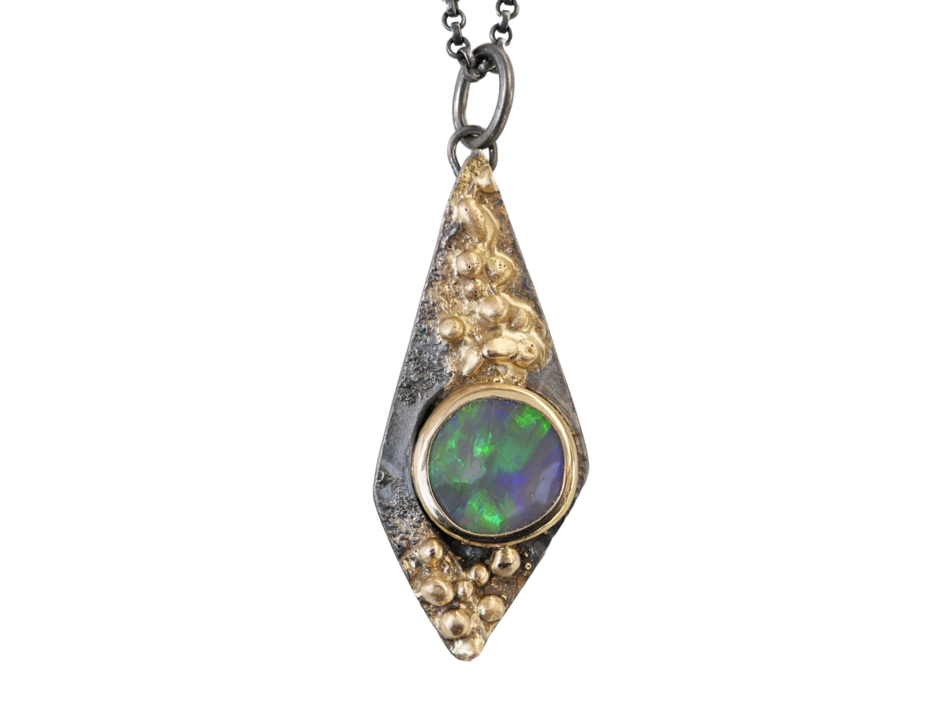 kite-shaped black opal pendant in 14k gold and oxidized sterling silver with green and blue hues on black opal gemstone