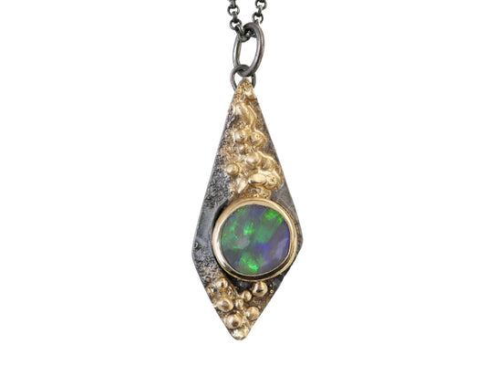 kite-shaped black opal pendant in 14k gold and oxidized sterling silver with green and blue hues on black opal gemstone