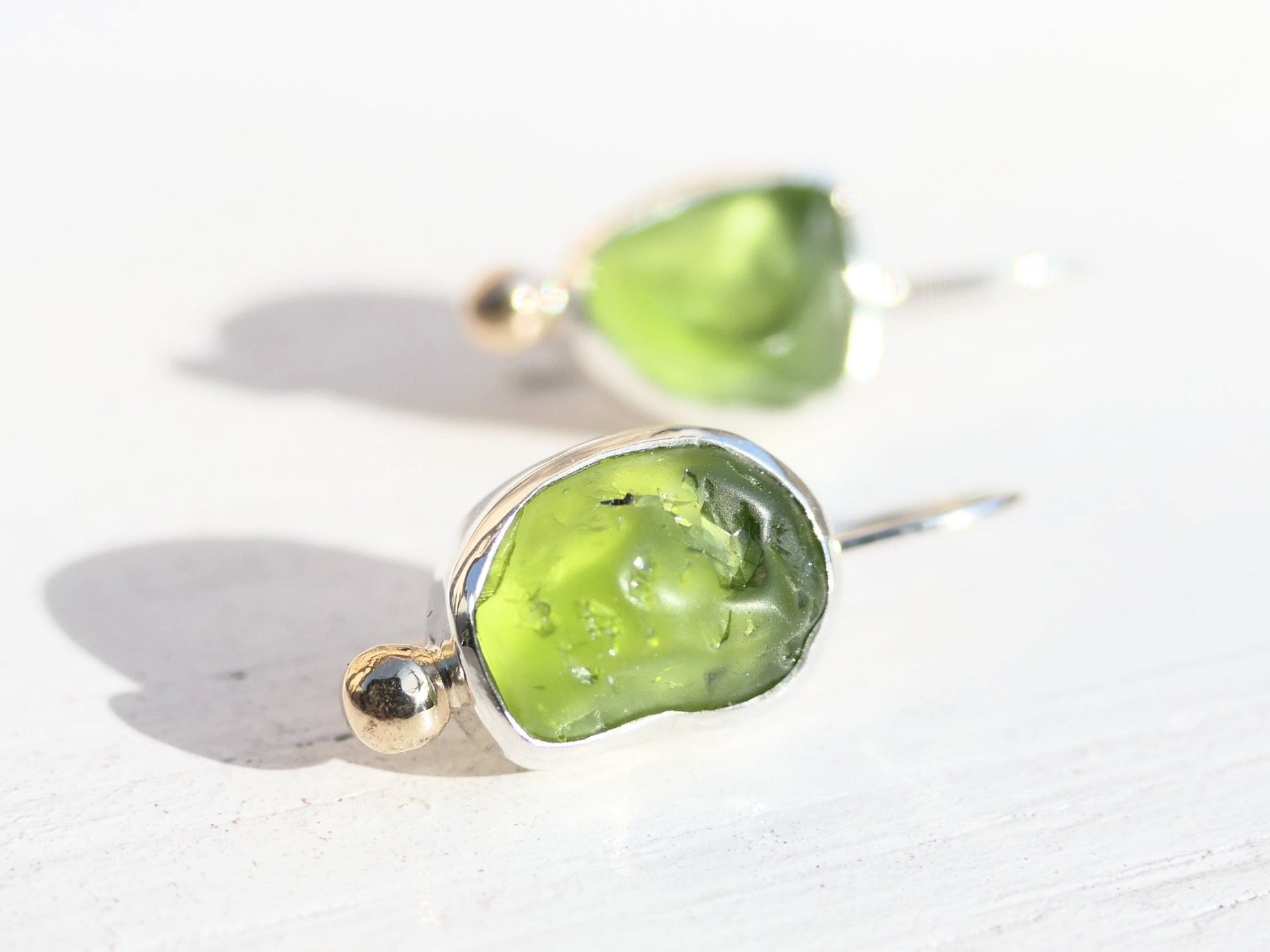 Handmade uncut peridot earrings with sterling silver and 14k gold accents.