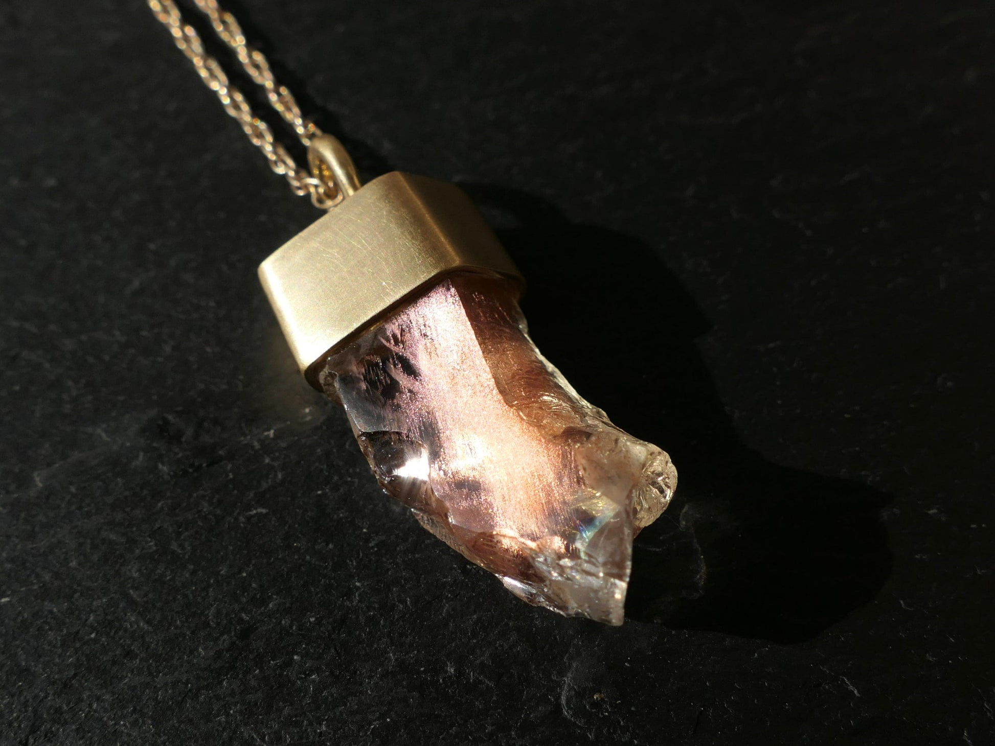 Oregon sunstone pendant in 18k gold with peach schiller and rainbow effect.