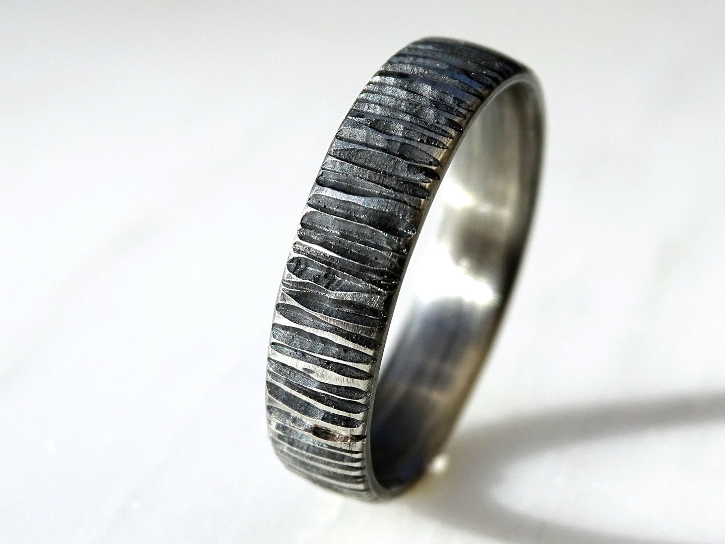 Handcrafted sterling silver men's ring with carved irregular lines and dark oxidized finish, unique and comfortable band.