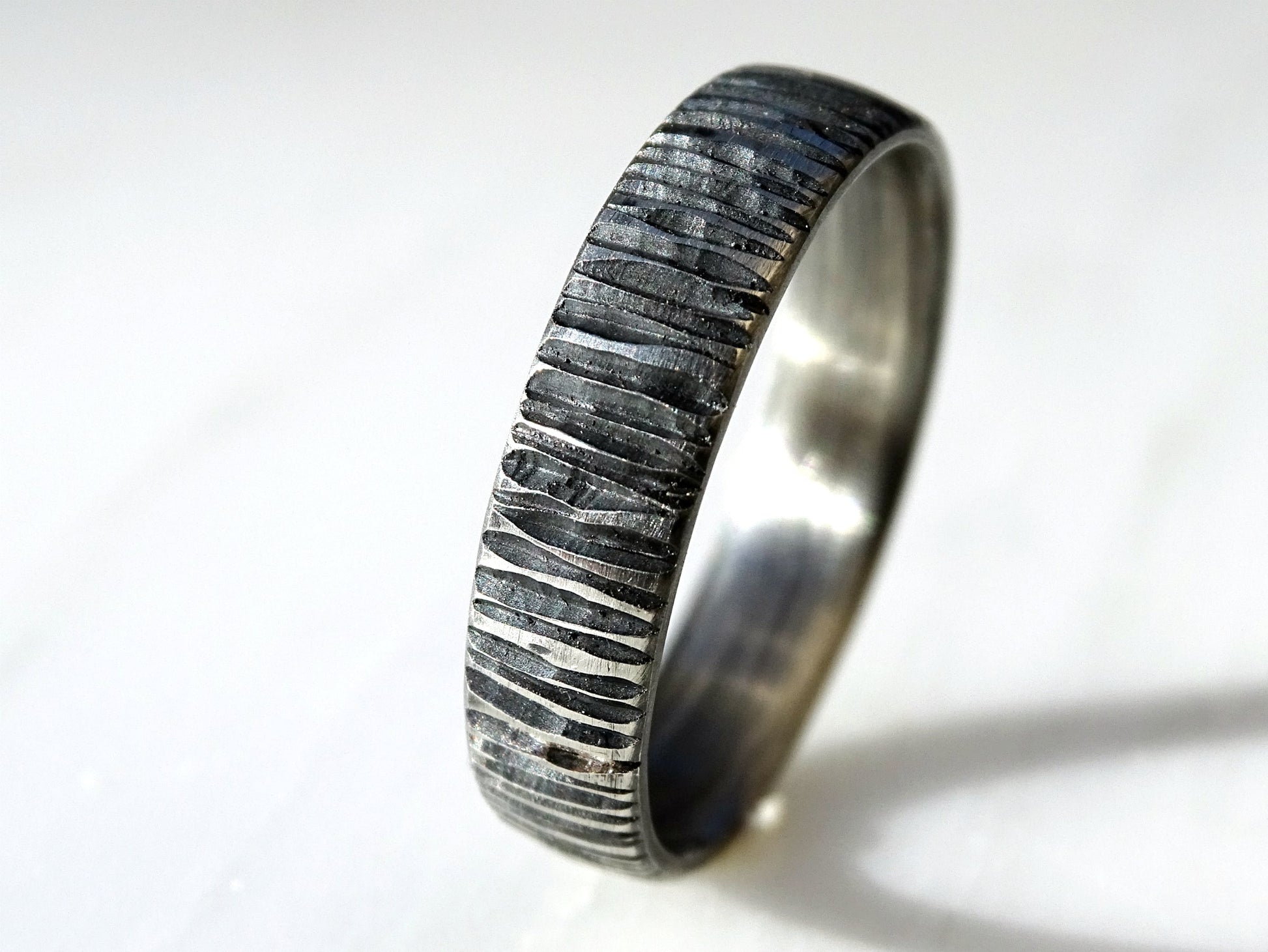Handcrafted sterling silver men's ring with carved irregular lines and dark oxidized finish, unique and comfortable band.