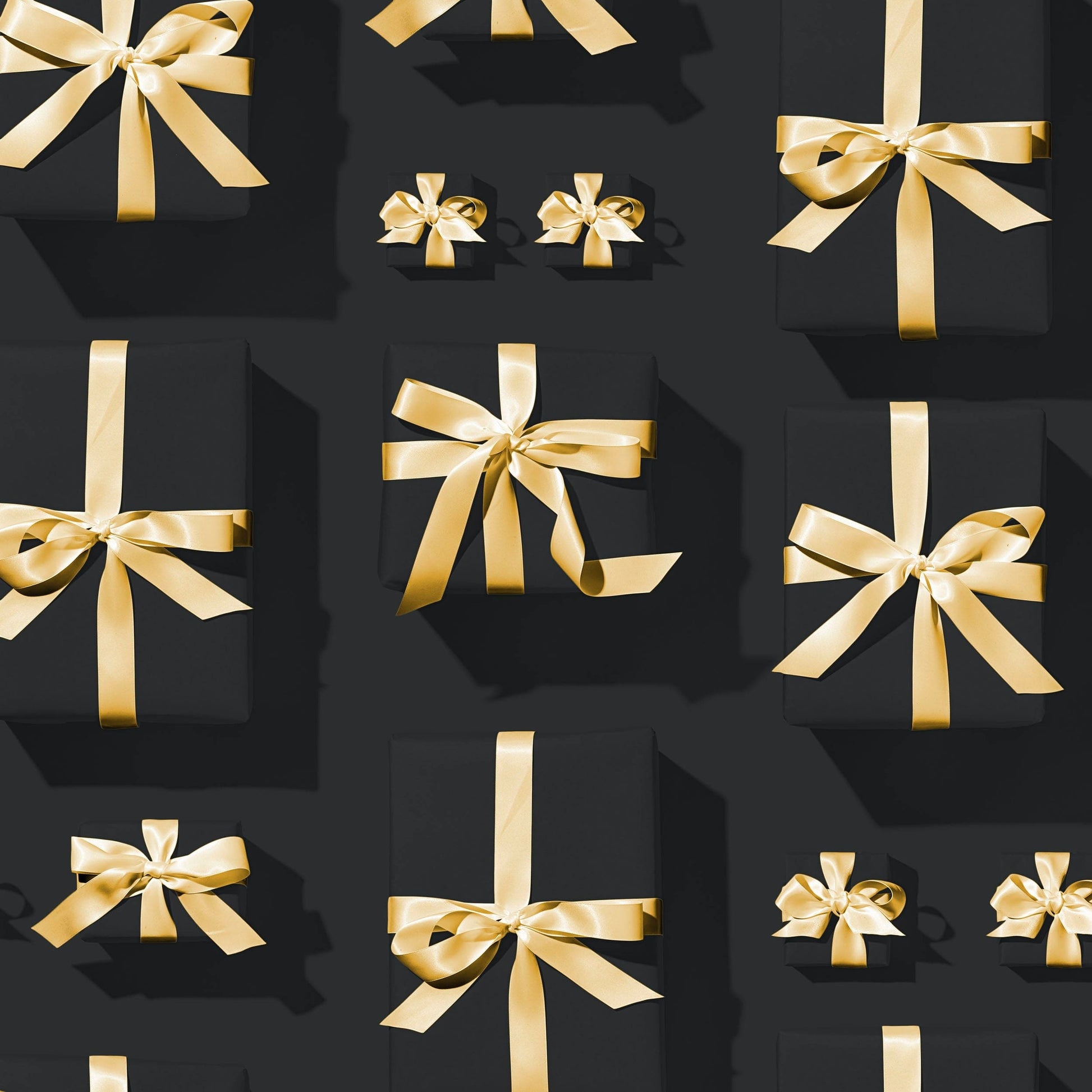 Black gift boxes with gold ribbons symbolizing CrazyAss Jewelry Designs gift card present options