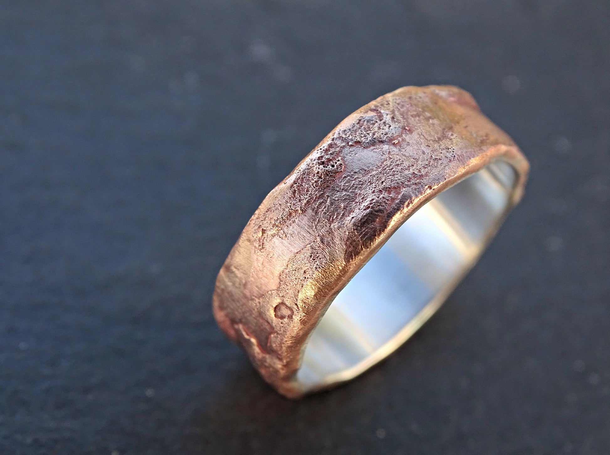handcrafted molten bronze silver ring with textured surface and silver lining