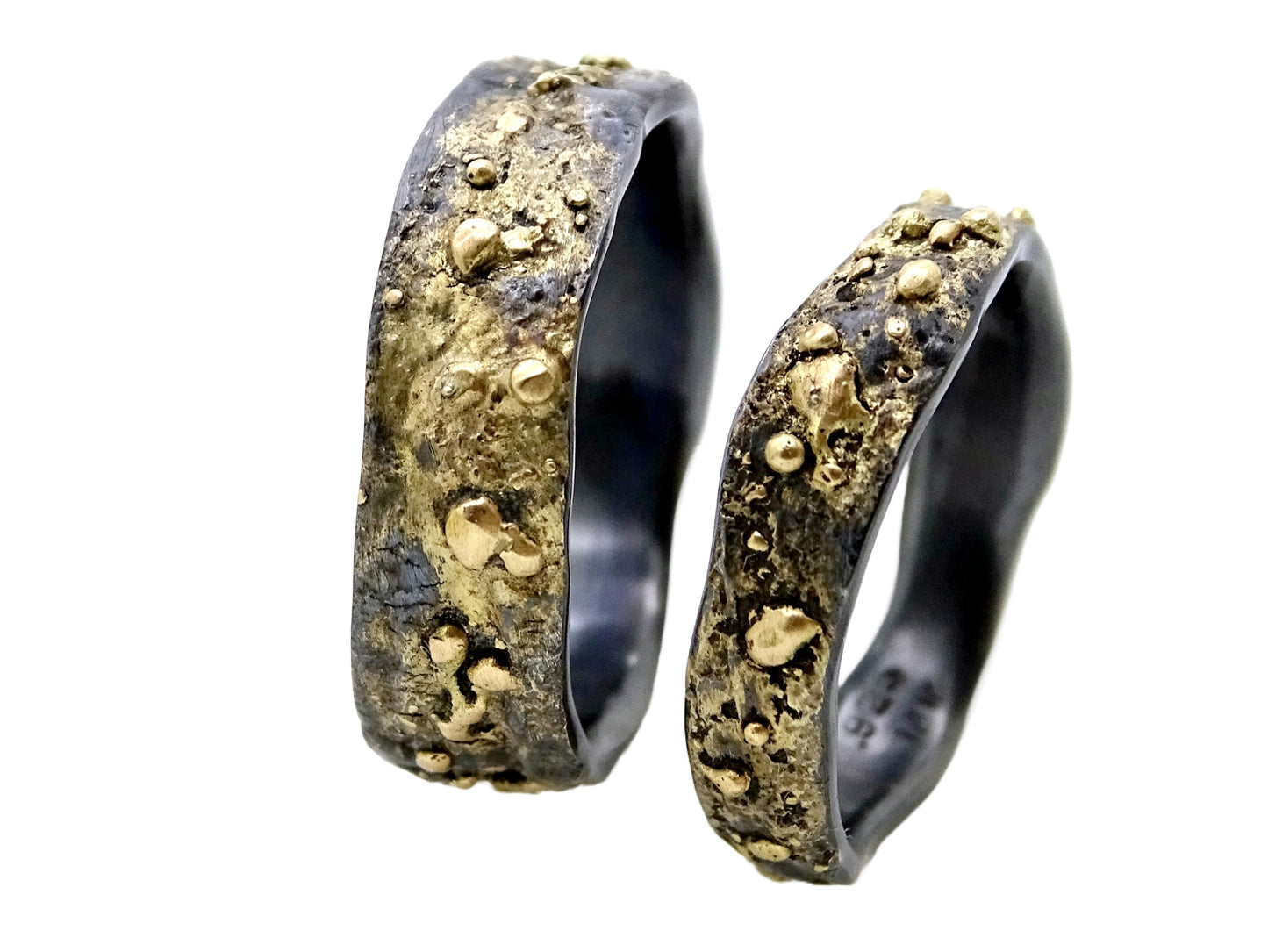 Handmade men's gold wedding bands with textured 14k gold and black sterling silver finish, matching set with 6mm and 4mm widths.