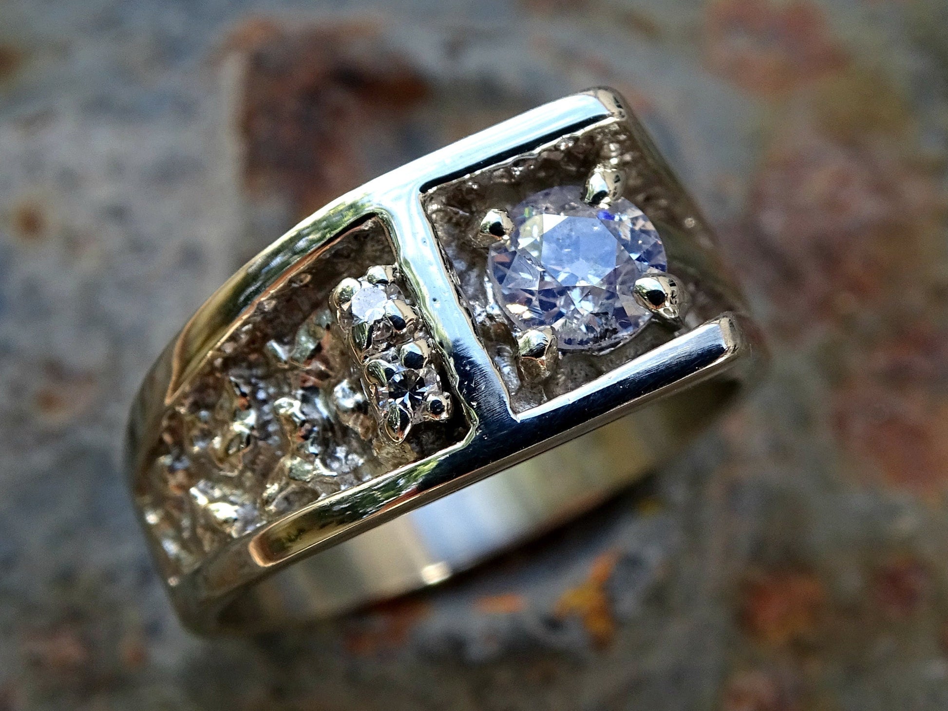 men's white gold diamond ring with 0.66 carat center stone and two smaller diamonds on a solid 14k band